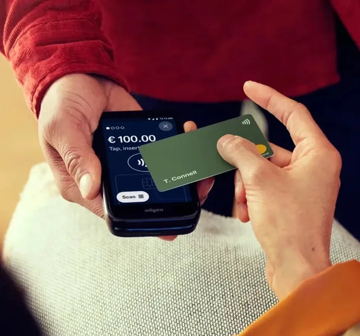 Customer tapping a card on a handheld reader